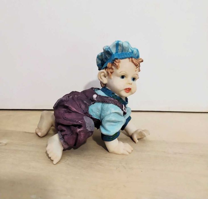Estatuetas meninos a gatinhar