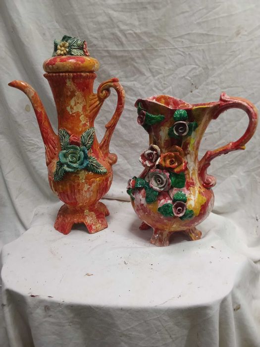 2 Jarros louça em tons rosa com flores em alto relevo.