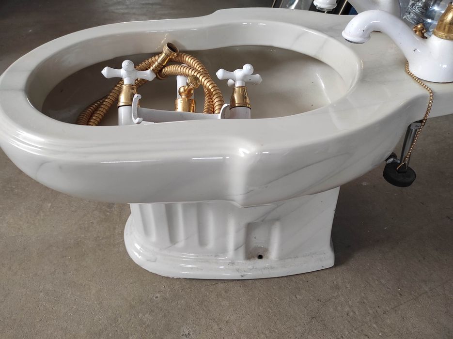 Conjunto de bidé clássico com torneiras e torneira de banheira também clássica.
