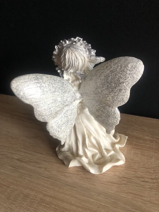 Figurka z żywicy Aniołek z różą i koszem kwiatów w ręku.