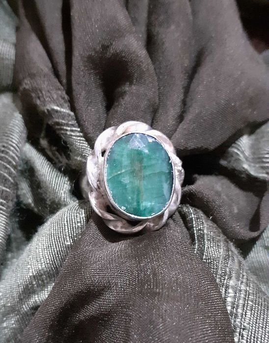 Anel em metal com pedra verde em destaque