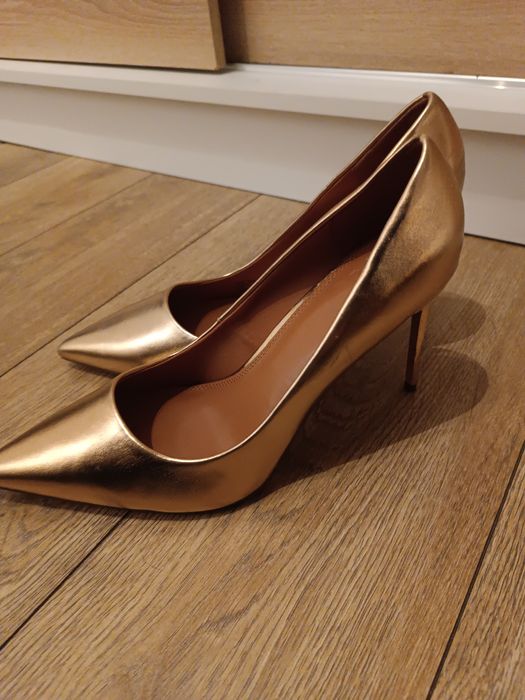 Złote wysokie szpilki