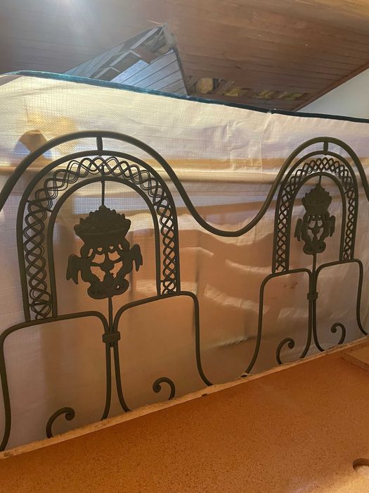 Cama de casal em ferro com colchão e estrado.