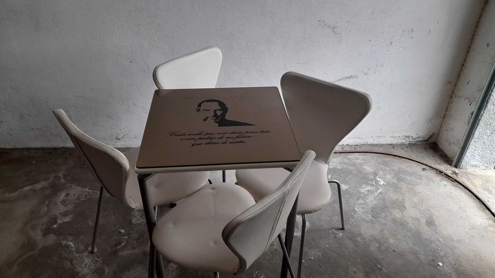 4 mesas com 16 cadeiras, personalizada com grandes figuras desenhadas.