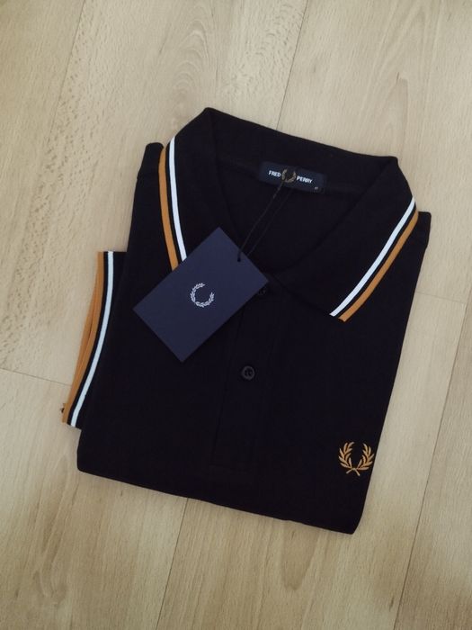 Pólo Fred Perry preto com listas brancas e amarelas.