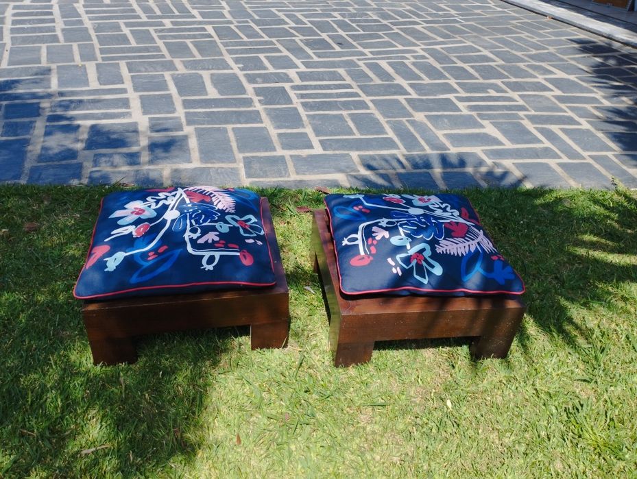 Dois bancos de jardim com almofadas.