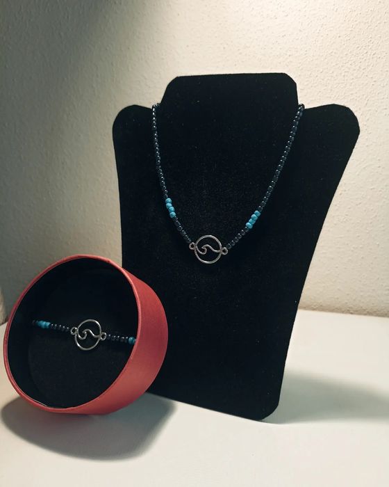 Conjunto de colar e pulseira sobre o mar