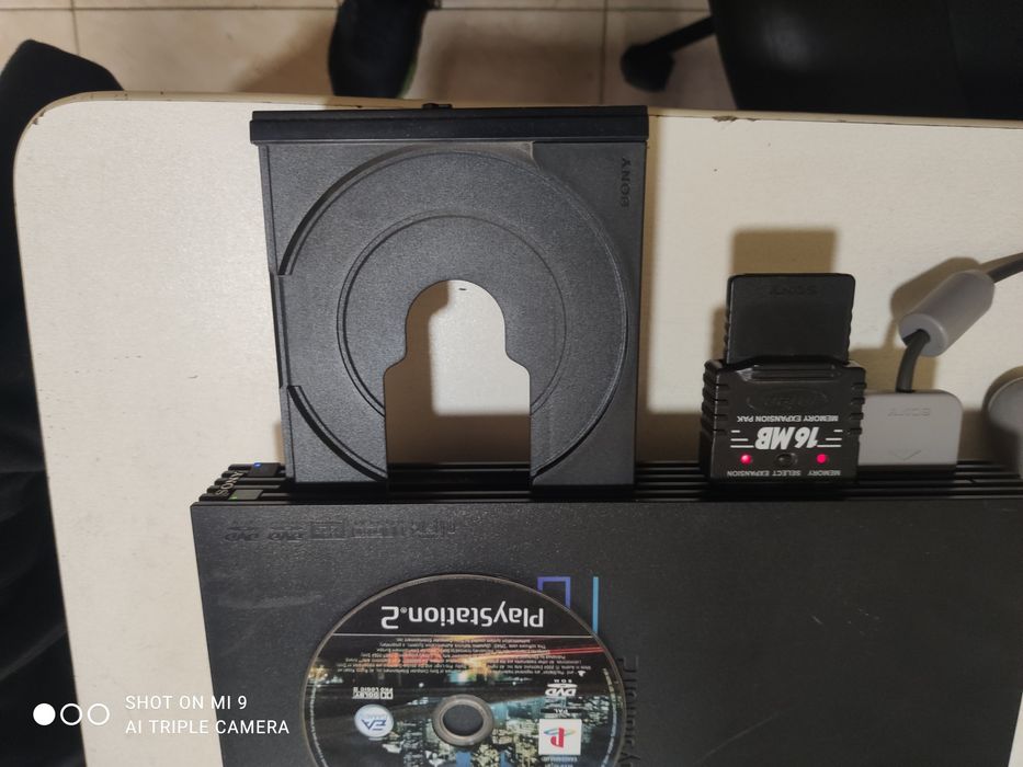 PS2 com comando e um jogo