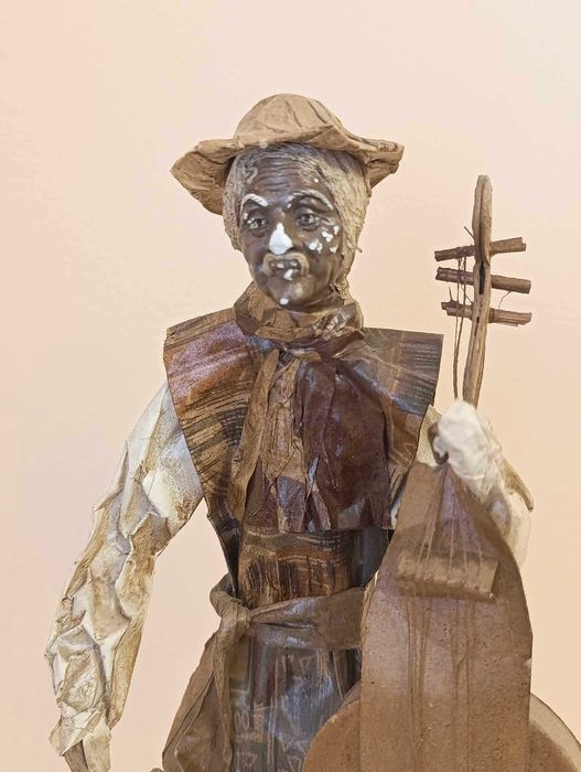 Figura artesanato homem com violoncelo em papel maché