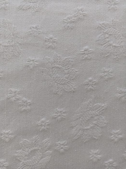 Toalha de mesa branca com motivos florais em destaque