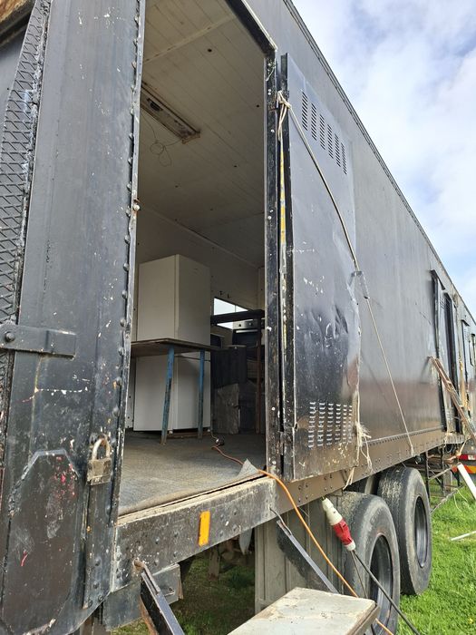 Reboque com devisoes de camata, cozinha e duche.