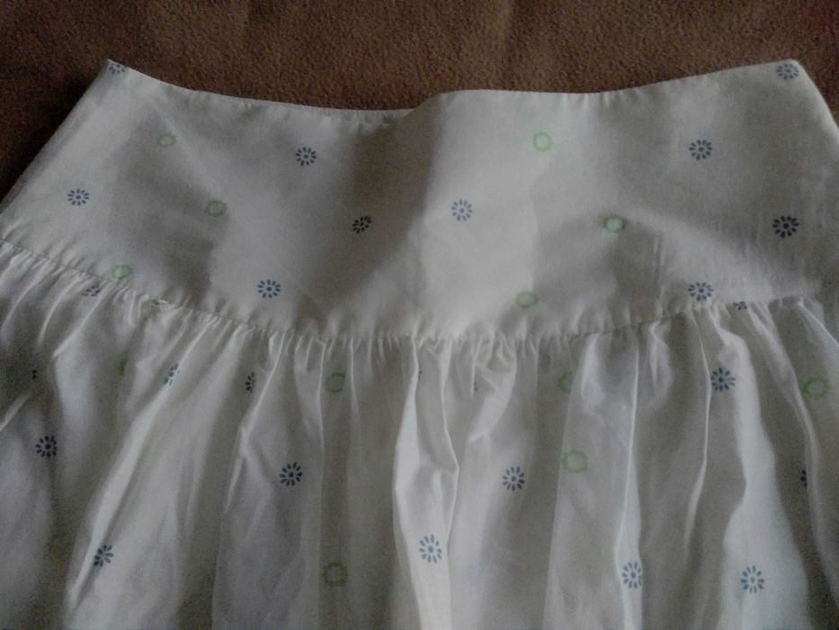 Saia curta, fundo branco e barra florida