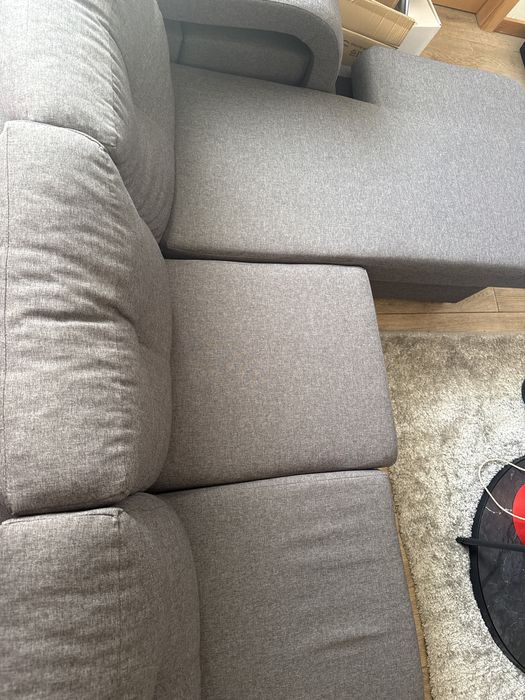 sofa cinza e conta com 4 puffs
