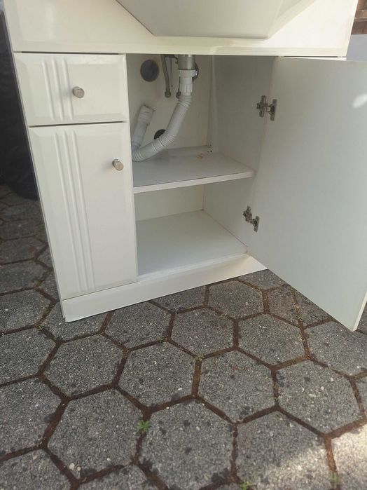 Móvel de casa de banho usado com lavatório em cerâmica e torneira.