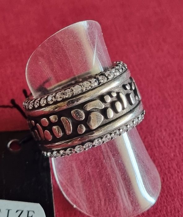 Anel prateado, em aço envelhecido, com fundo preto e zirconias. T18