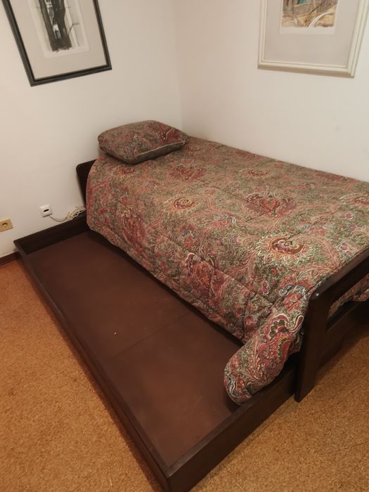 Cama de solteiro com cama auxiliar.