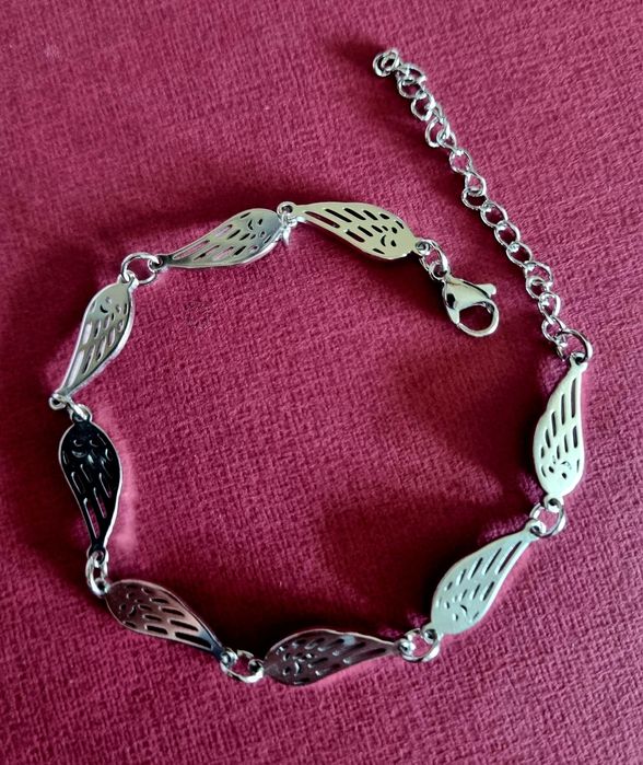 Conjunto prateado (colar e pulseira), em aço,  com asas de anjo.