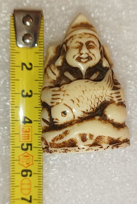 Antigo netsuke homem velho com peixe