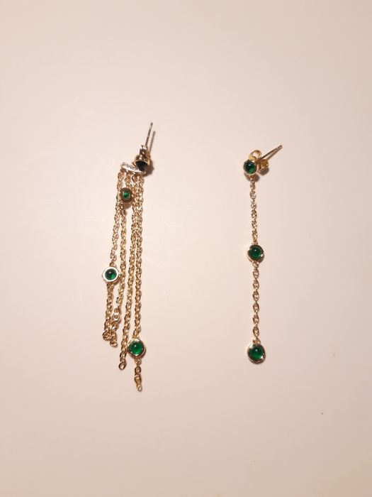 Brincos dourados, assimétricos, com pedrinhas verdes
