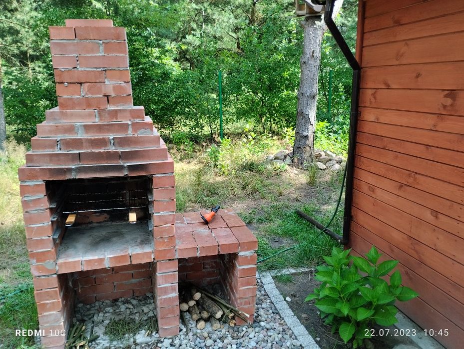 Domek nad zalewem na ogrodzonej działce.