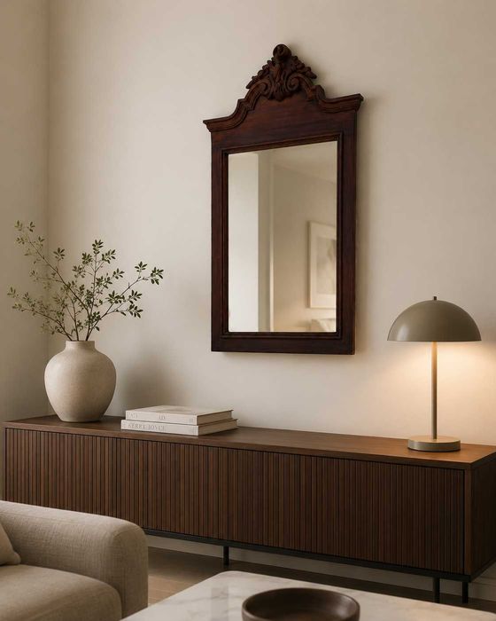 Espelho antigo em mogno, com moldura trabalhada e detalhe decorativo no topo