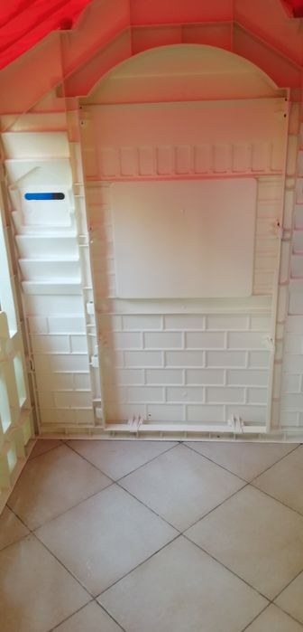 Casa de jardim de criança de plástico com telhado vermelho em bom estado