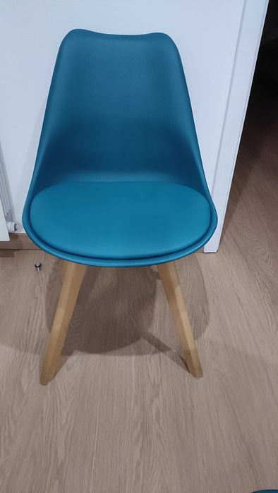 Cadeiras azul petróleo com penas em madeira