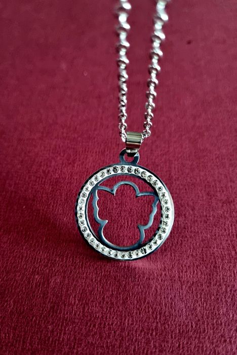 Colar prateado, em aço, pingente de anjinho rodeado de zirconias