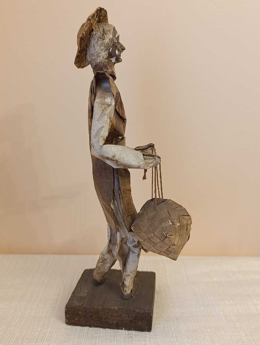 Figura de artesanato homem em papel maché com cestos
