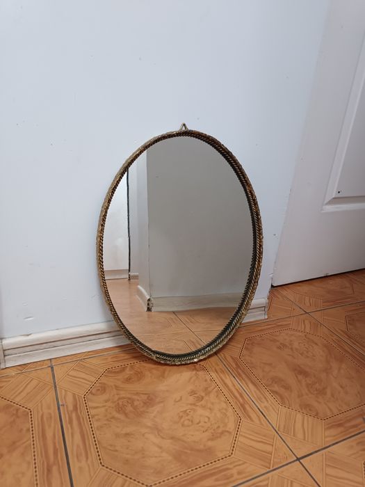 Stare w złotej metalowej ramie lustro