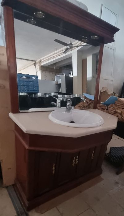 Armário de WC em madeira e pedra mármore e espelho com focos.