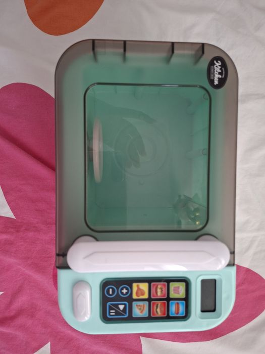 Microondas de brinquedo e loiça de brincar.