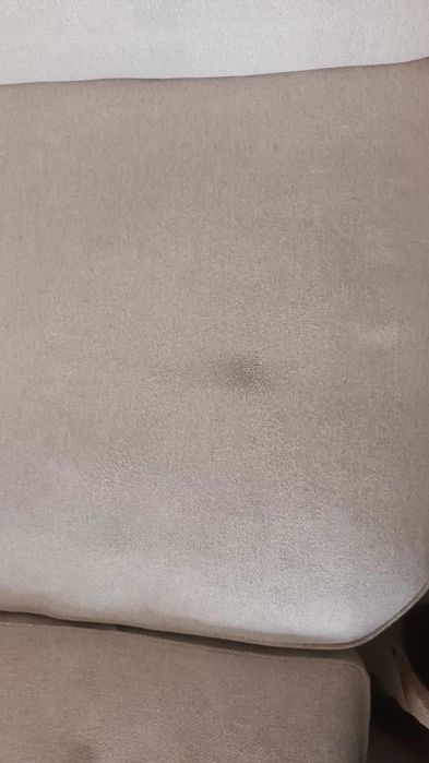 Sofá de canto bege, gato preto