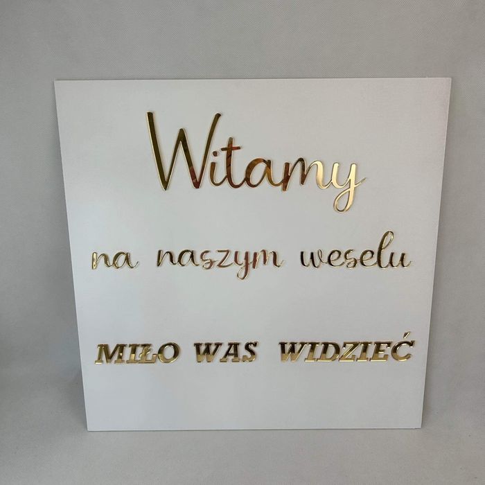 Tablica powitalna ze złotymi napisami