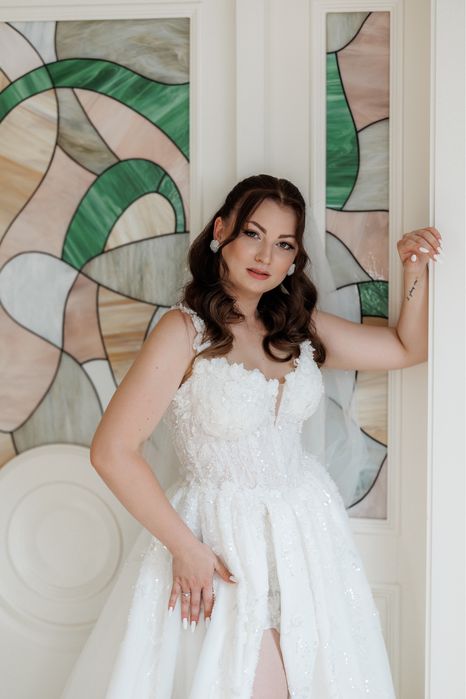 Весільна сукня білого кольору оздоблена квітами з розрізом