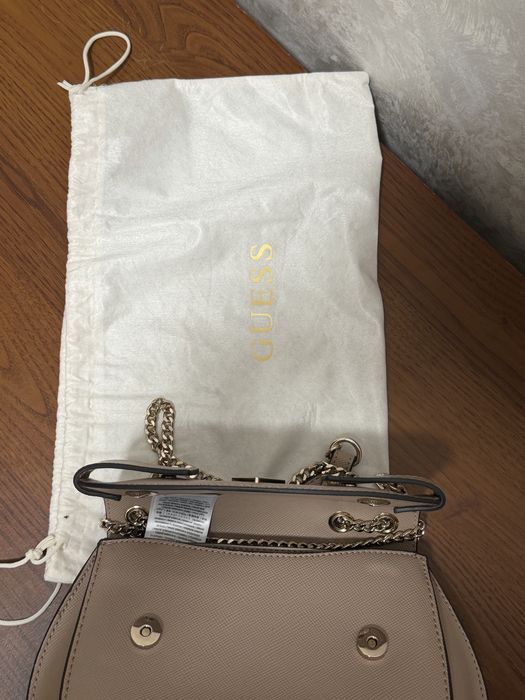 Сумка Guess Serenova Saffiano із саф'яновою текстурою екошкіри, золотистою фурнітурою та фірмовим трикутним логотипом.