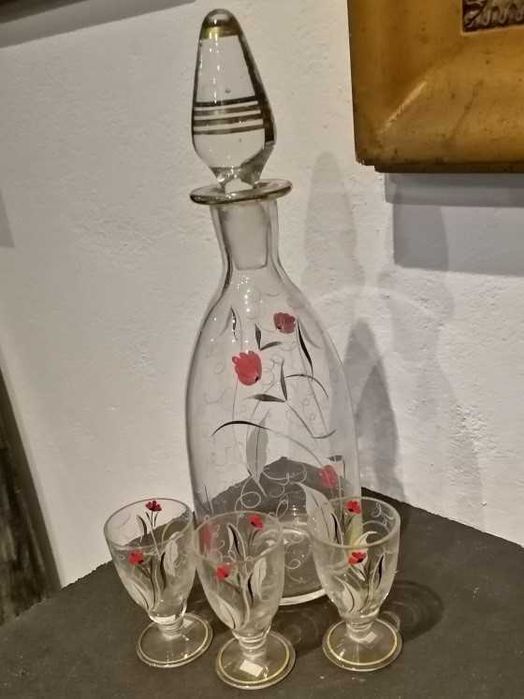 Garrafa de licor e três copos em vidro