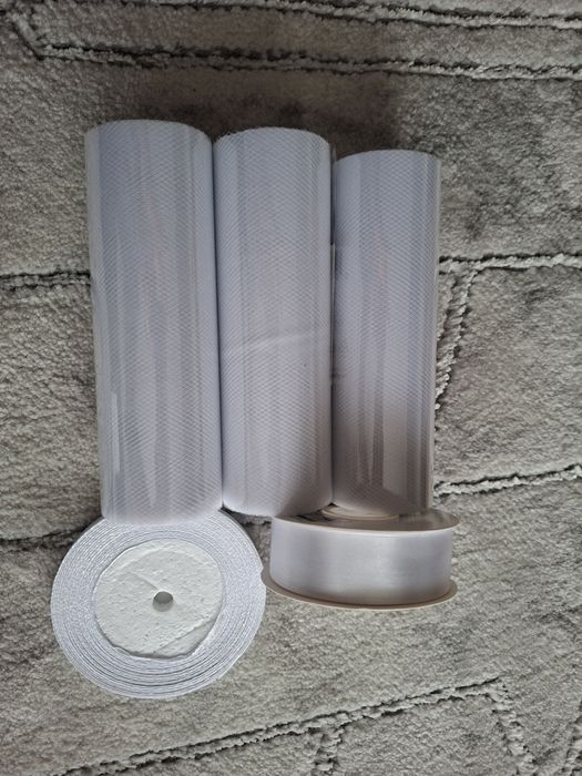 Białe tiule i satynowe wstążki.