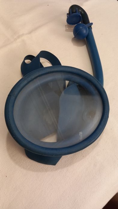 Máscara de mergulho azul com um tubo de respiração acoplado, comumente usada para snorkeling ou natação recreativa.