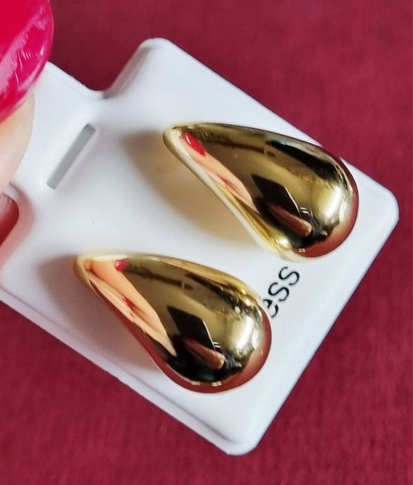Pequenos brincos dourados, em aço, em forma de gota. De pico
