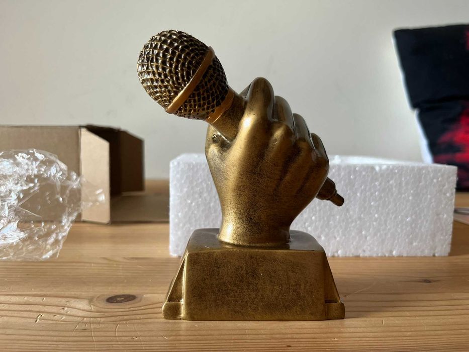 Trofeu mão com microfone dourado