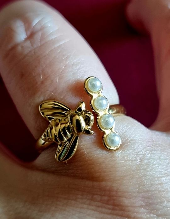 Anel dourado, em aço, com abelha e 4 micropérolas. Ajustável