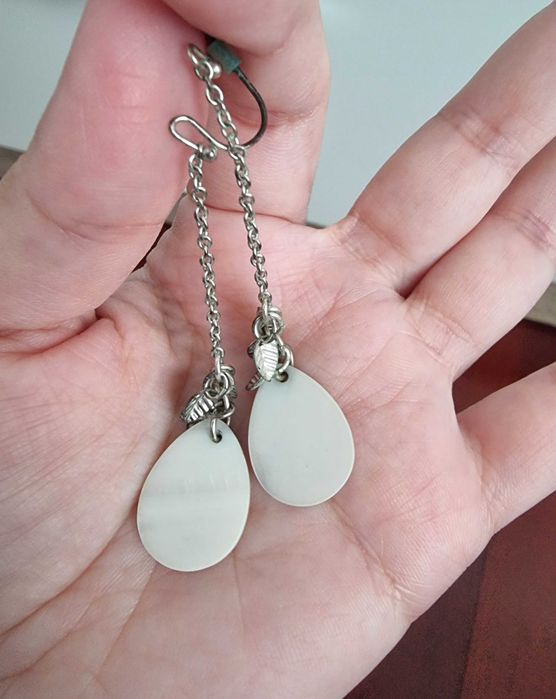 Brincos brancos e prateados com detalhes de folhas