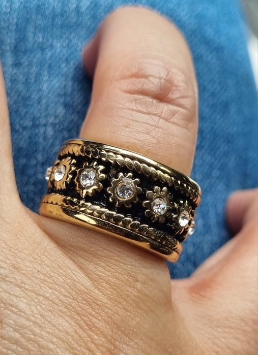 Anel dourado, em aço, com pontos de luz em fundo preto a toda a volta. T19