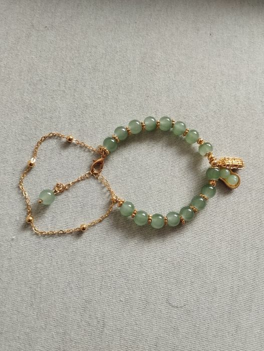 Bransoletka w złotym kolorze. Zielone akrylowe koraliki i zawieszka
