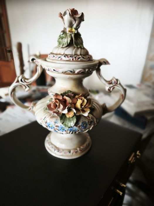 peça cerâmica decorativa ou uma peça de porcelana. Tem a forma de um vaso ou urna com duas pegas, com uma tampa separada