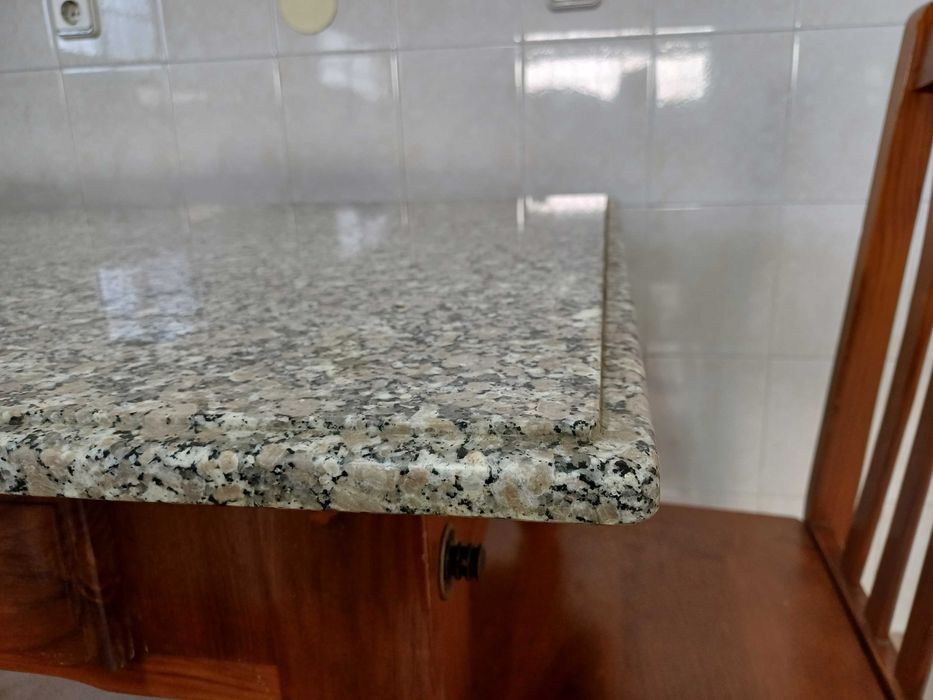 Mesa de cozinha com tampo em granito polido e quatro cadeiras.