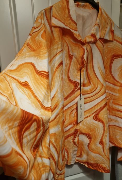 Camisa em tons laranja, tecido acetinado, mangas morcego. Oversized