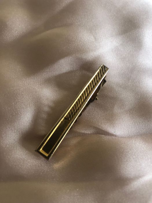 Peça dourada para segurar gravata a camisa