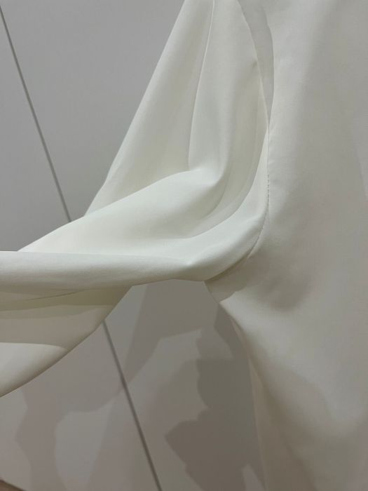 Blusa branca de manga comprida com elasticos na manga e costas abertas